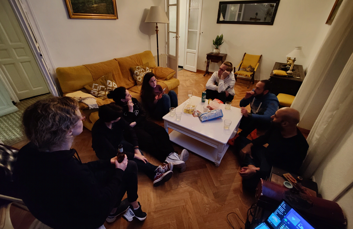 A group of friends sitting in a warm indoor setting, chatting and enjoying their time together