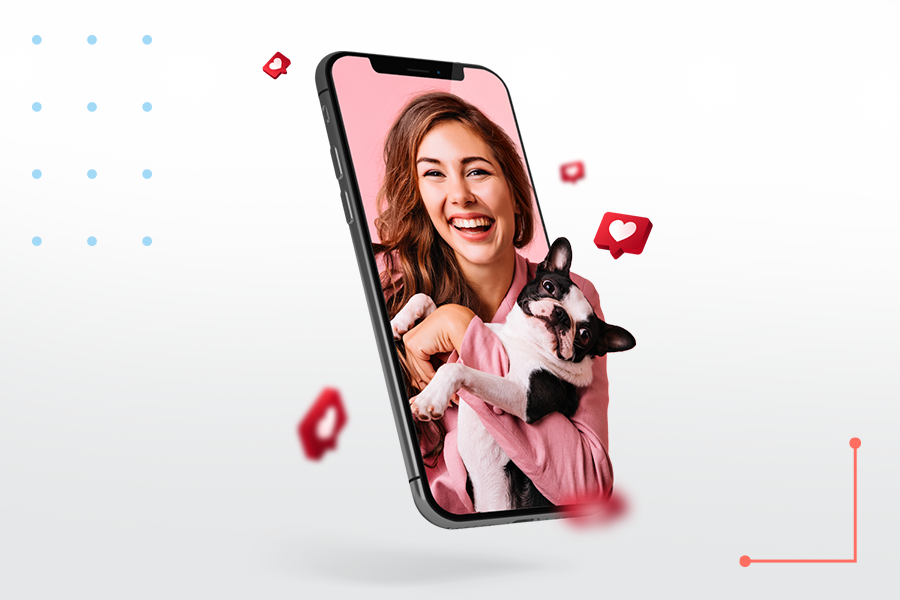 Smiling woman holding a dog, emerging from a smartphone screen with floating social media like icons, symbolizing digital engagement and influencer marketing